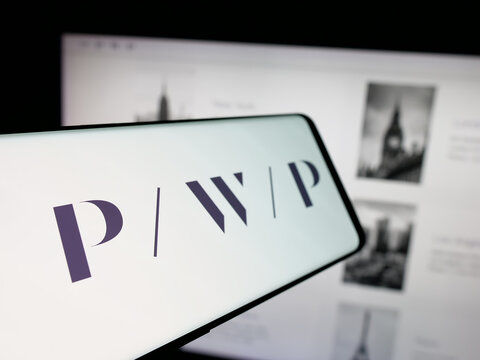 Stuttgart, Germany - 11-19-2025: Smartphone with logo of US company Perella Weinberg Partners (PWP) on screen in front of website. Focus on left of phone display.