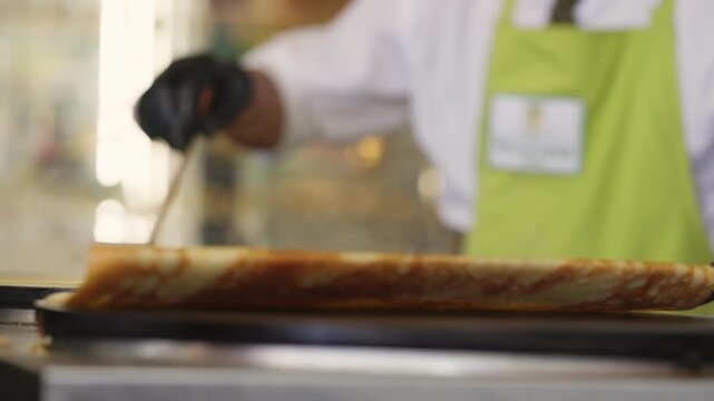 Close up view in slow motion of A Chef flipping a crepe in a restaurant in Paris