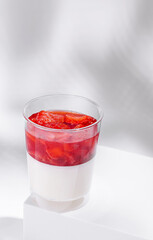 Delicious dessert with layered strawberry and cream in a clear cup