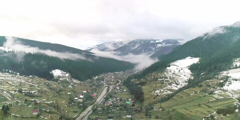 Top of view to mountain village and foggy green field