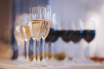 Elegant glasses filled with white and red wine set against a softly lit background during a celebration or gathering