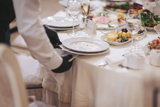 Elegant dinner preparation in a well-decorated dining hall during a formal event with beautifully arranged dishes and attentive service