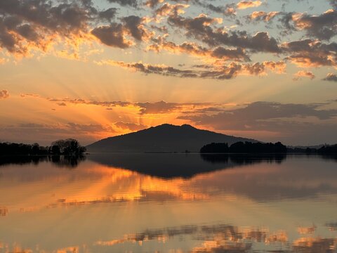 Golden sunburst behind the Santa Trega mountain over the serene river Minho at sunset, Vila Nova de Cerveira, Viana do Castelo, Portugal, November 2024