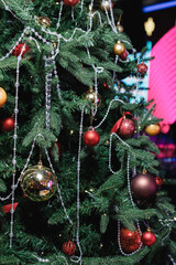 Close-up of a Christmas tree with red baubles and silver bead garlands