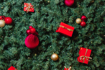 Top-down view of a Christmas tree decorated with red gifts and golden ornaments