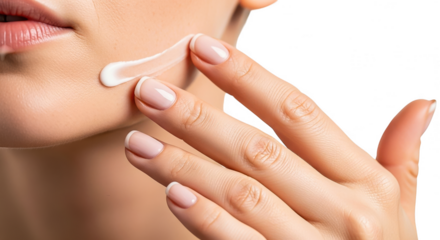 Closeup of womans hand applying face cream to her cheek, isolated on transparent background