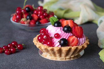 Homemade shortbread baskets with cream and fresh berries on gray background