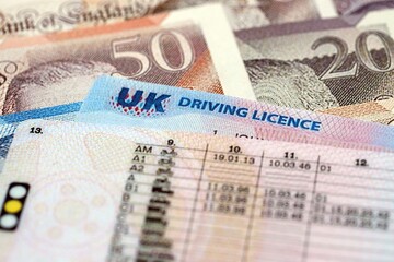 United Kingdom driving license card on UK British pounds money close up