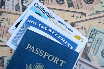 Obraz premium Social security number and California driving license with passport on US dollar money bills close up