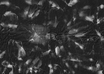 Abstract white paint texture on crumpled black paper background. Grunge and distressed graphic element. For artistic overlay template.