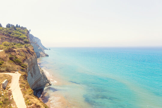 Aerial view of high coastal cliffs over turquoise Ionian sea bay