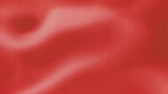 A close-up view of a textured red background with subtle wavy patterns.