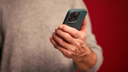 Closeup, man holding mobile phone text message, scrolling, watching video selective focus on hands