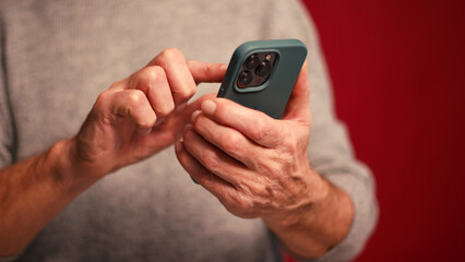 Closeup, man holding mobile phone text message, scrolling, watching video selective focus on hands