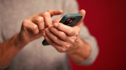 Closeup, man holding mobile phone text message, scrolling, watching video selective focus on hands