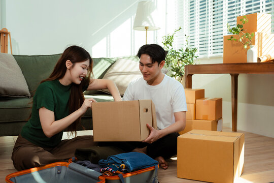 young couple helps put things in boxes and prepares to move to a new house.