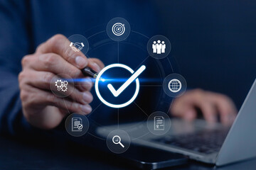 A businessman using a digital interface with a glowing check mark symbol, representing approval, quality assurance, verification, and modern business standards for reliable workflow management.