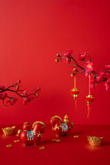 Naklejka premium Side vertical view. Red backdrop with gold ingots and coins, festive horses, and plum blossoms. Bright lanterns hang, symbolizing celebration, prosperity, luck, and blessings