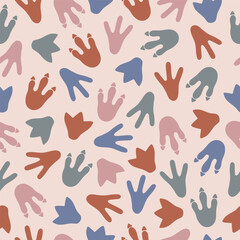 Seamless pattern with colorful dinosaur footprints on beige background. Template for print, fabric, wallpaper, wrapping paper