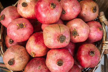 Pomegranates in a wicker basket on a market stall