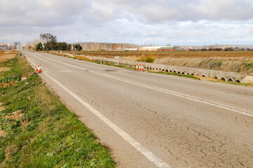Old road under construction with roadwork signs in the countryside.