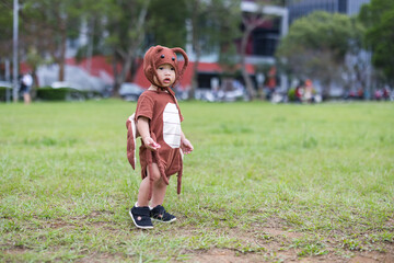 Toddler wearing cockroach costume enjoying Halloween celebration outdoors