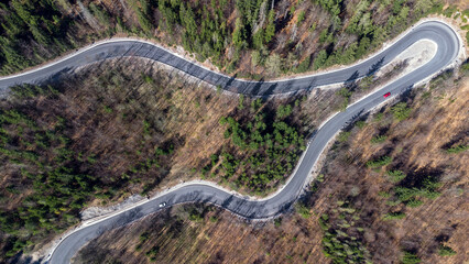 Aerial view winding forest road cars.