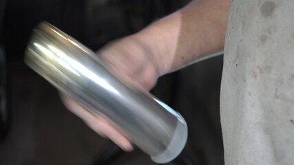 A man shakes a metal can of paint. Paint materials and tools are used to bring creative projects to life, demonstrating craftsmanship and innovation.