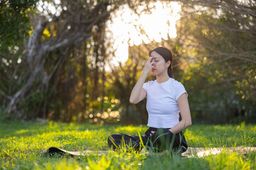 Young woman doing pranayama breathing exercise outside