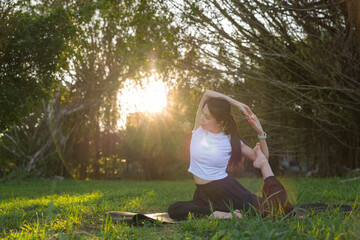 Woman practicing yoga outdoors in sunlight