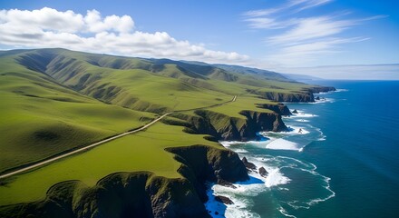 Aerial view of rugged coastline with green hills and cliffs meeting the deep blue ocean under a partly cloudy sky