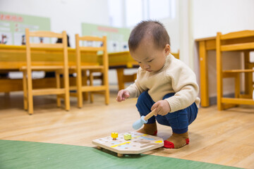 Baby having fun playing inside colorful indoor playhouse
