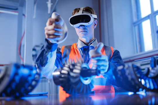 Young caucasian male engineer using vr headset for industrial machinery simulation