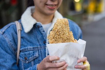 Woman enjoying Taiwanese fried chicken at restaurant