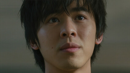 Young person with slightly messy hair looking up with a thoughtful expression