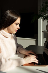 girl typing on laptop at home workspace