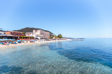 Crowded Mediterranean beach with hotels and turquoise shallow water
