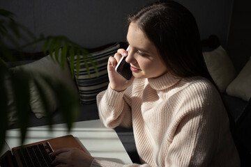 girl talking on smartphone while working at desk