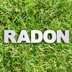 Radon: the natural radioactive gas that comes from the earth - concept image with radon text over a green mowed lawn