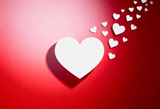 White heart shape with small hearts forming a trail on a vibrant red background for Valentines Day