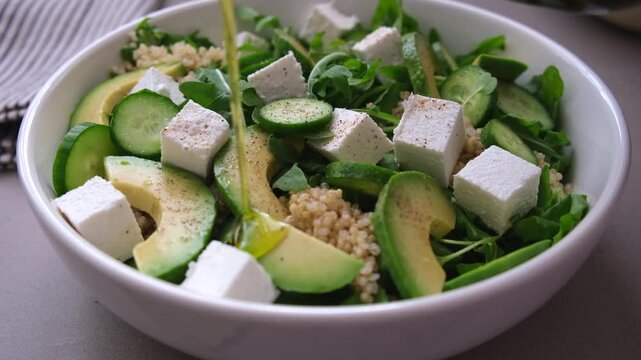 Green quinoa salad with cucumber, arugula, avocado and feta.