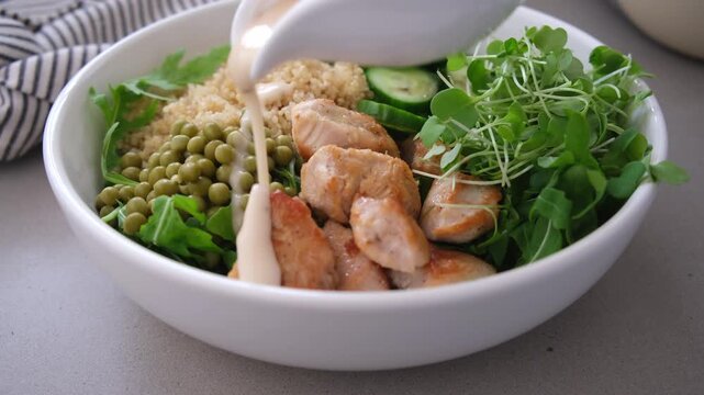 Balanced quinoa salad bowl with chicken, cucumber and pea for lunch.