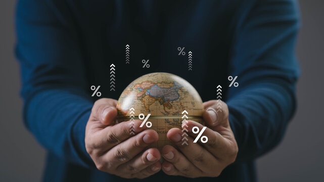 A person holding a small globe with rising percentage icons, symbolizing global economy growth, financial trends, investment opportunities, and international market expansion.