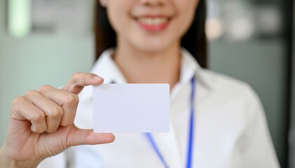 Business Card Presentation: A smiling individual presents a blank business card, symbolizing networking and communication in a professional setting. 