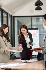 Group of Asian businesspeople sits down for a business investment planning meeting.	