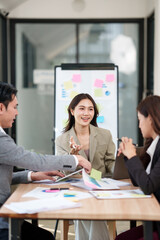 Group of Asian businesspeople sits down for a business investment planning meeting.	