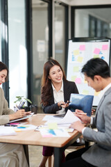 Group of Asian businesspeople sits down for a business investment planning meeting.	