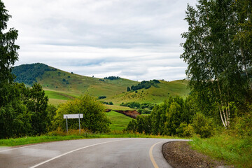 Scenic view of a lake with grassy banks and hills in the background.