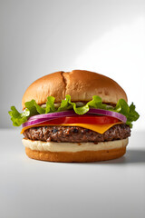Classic cheeseburger with red onion, lettuce, and tomato on brioche bun against white background