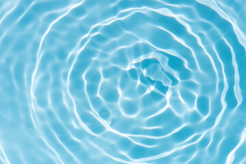 Blue water with ripples on the surface. Defocus blurred transparent blue colored clear calm water surface texture with splashes and bubbles. Water waves with shining pattern texture background.